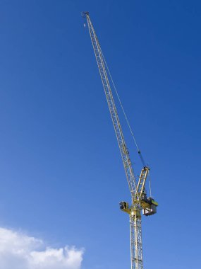 Tower crane high in sky at construction site UK clipart