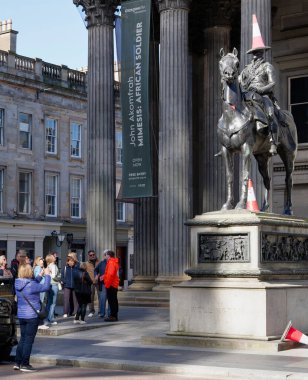 Glasgow turistleri, Wellington Dükü Arthur Wellesley 'in binicilik heykeli önünde