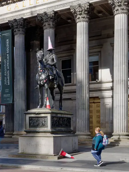 Glasgow, İngiltere, 4 Mayıs 2025, Glasgow turistleri, Wellington Dükü Arthur Wellesley 'in binicilik heykeli önünde