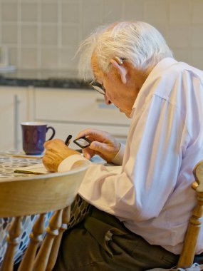 Üst düzey yaşlı adam, İngiltere çapraz bulmaca çözerek zihnini aktif tutuyor.