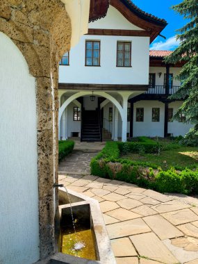 Sokolski Manastırı bahçesindeki çeşmenin manzarasını kapat. Arka planda eski bir miras binası var..