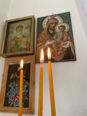 Dini simgelerin önüne üç mum konur ve kilisenin içinde dinsel ve ruhsal bir atmosfer yaratır..