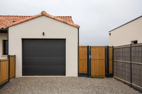 新しい家の断面傾斜黒ガレージのドアと入り口の門 — ストック写真