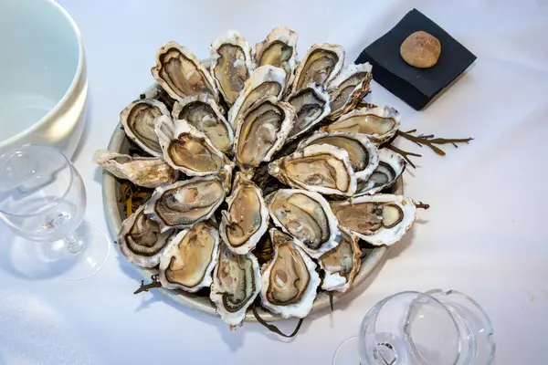 餐桌上的平底锅上放着新鲜的牡蛎 — 图库照片