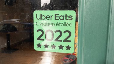 Bordeaux, Aquitaine France - 11 12 2022: Uber livraison etoilee işareti logosu ve marka metin cephe pencereleri girişi yapan ABD 'li uluslararası gıda dağıtım restoranı yiyor