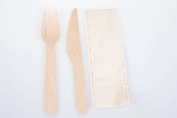 木製フォークナイフと茶色のナプキンはリサイクル紙から白い背景に隔離されています — ストック写真