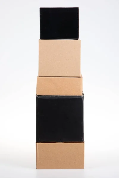 Коричневые Черные Картонные Коробки Сложены Друг Друге Пирамиды Белом Сером — стоковое фото