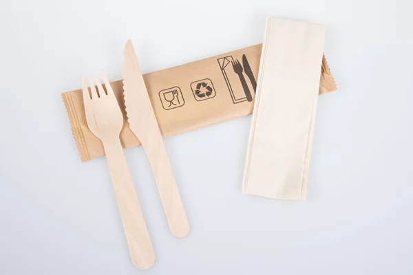 木製フォークナイフとリサイクル可能なナプキン白地に隔離された包装 — ストック写真