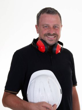 Arkaplanda koruyucu miğferi olan gülümseyen yakışıklı iş adamı.