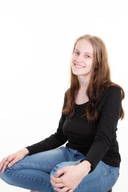 Attractive blond young woman portrait of beautiful girl sitting cross-legged on a white background