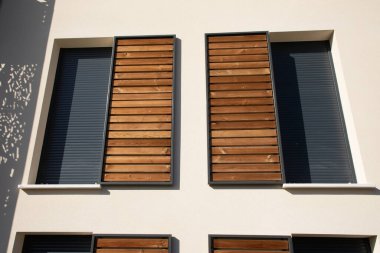 Yeni apartman binasında modern ahşap kaydırak panjurlu ev pencereleri