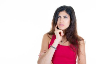 Güzel genç bir kadın beyaz arka planda beyaz fotokopi alanına karşı poz verirken düşünceli bir şekilde yan yana sevimli bir gülümseme sergiliyor.