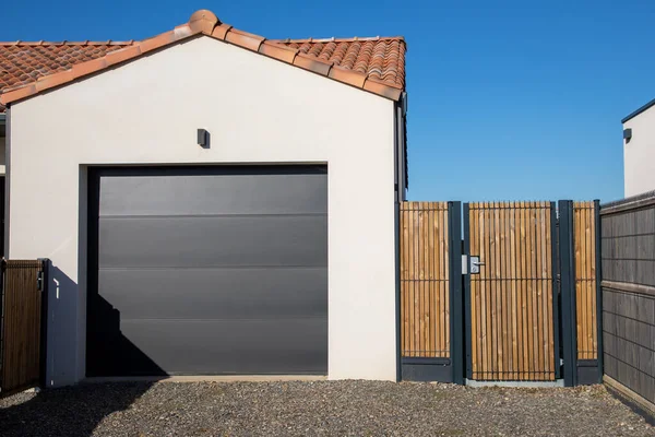 現代ホームグレー分割シーケンシャルゲートガレージポータル木造ドアアクセス庭と家の郊外の灰色のファサード — ストック写真