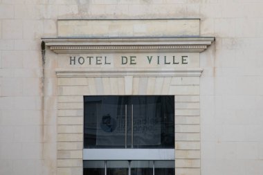 Belediye binasının ön cephesindeki Hotel de ville Fransızca metni Fransa 'daki belediye binası anlamına gelir.