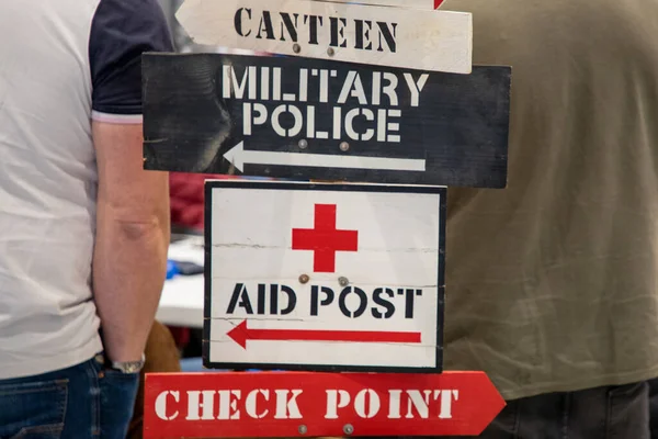 military police and Army Checkpoint sign on wooden panel arrow aid post and canteen