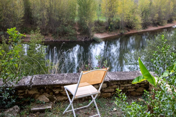 Evdeki Bir Nehrin Kenarında Boş Turuncu Bahçe Sandalyesi — Stok fotoğraf