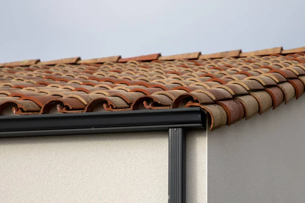 屋顶排水沟黑色和灰色的下水管在一个新的瓦片屋顶的正面灰色 — 图库照片
