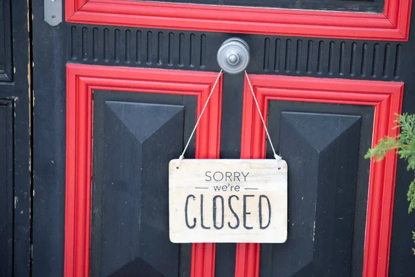 Sorry we are closed sign board wooden panel hanging on door of cafe