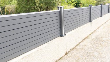 Gri alüminyum çit. Banliyö evinin yeni modern bariyeri. Gri sokak koruma evi.