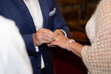 Gelin ve damat kilisenin kutlamaları sırasında evlilik yüzükleri alışverişi yapıyor.