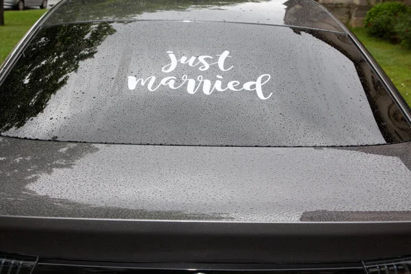 stock image just married sign in rainy wedding day rear view car