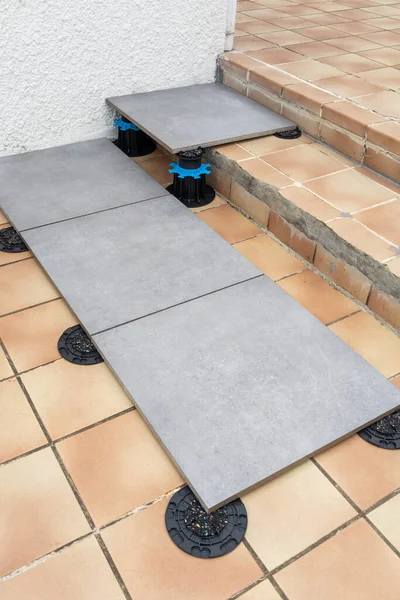 stock image floor tile with pedestal support with integrated slope plot corrector plastic studs adjustable pads