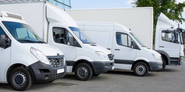 Fabrika deposunun önünde beyaz servis kamyonları kargo kamyonu filosu kurye servis arabaları