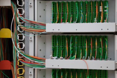 Fiber telefon santrali elektrik kabini. Açık mahalle telekomünikasyon kutusunun içinde DSL için bağlayıcı direkler ve kablolar var.