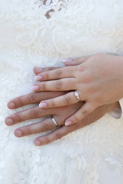 wedding couple rings fingers bride and groom hands on marriage wed resting on white dress