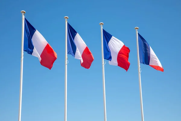 French flag four flags on 4 mat of France waving over a blue sky