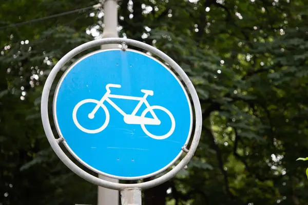 blue round sign bike path road signpost and cycle path markings reserved for two-wheeled bikes