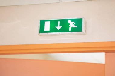 Kapısında lambalar olan yeşil çıkış işareti ofis binasında acil yangın koridoru