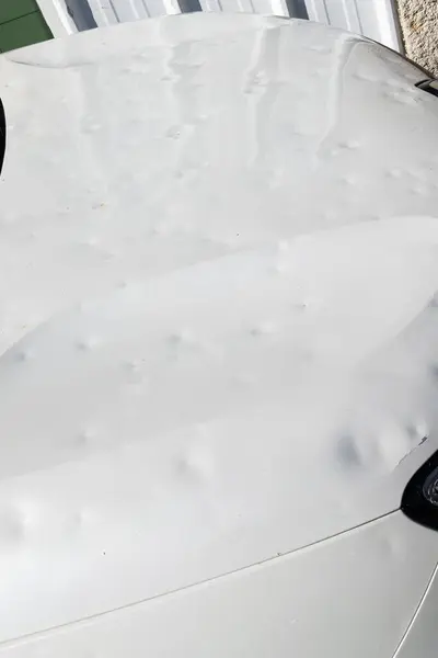 hail car hood damaged by hailstorm hailstone dented car bonnet