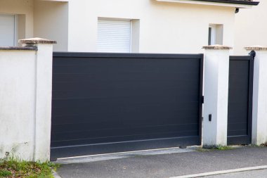 Gri kapı, yüksek metal kapı ve modern banliyö evinin ön cephesindeki gri kapı.