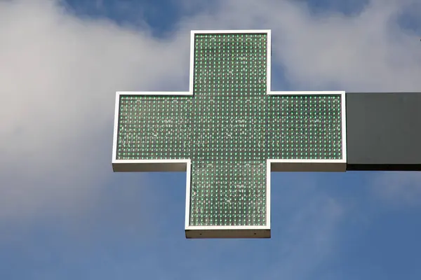 green cross illuminated led sign pharmacy dispensary in chemist concept health and medical
