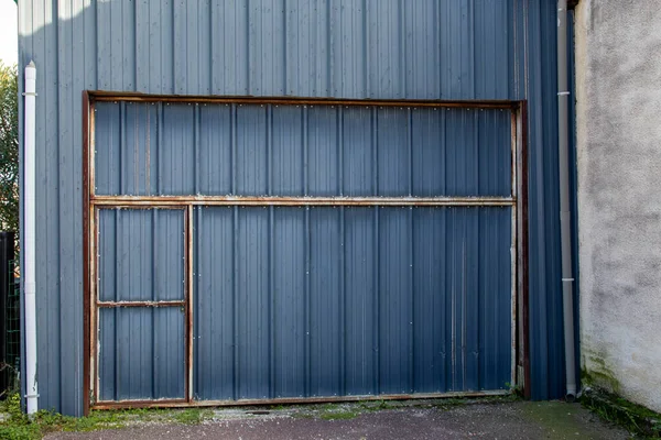 old ancient metal door for access to the barn garage rusted by time wall surface Fence house zinc background