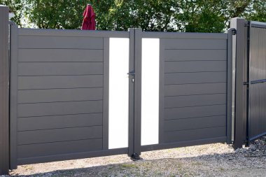 Gri alüminyum modern ev. Yeni banliyö evinin yüksek gri kapısı.