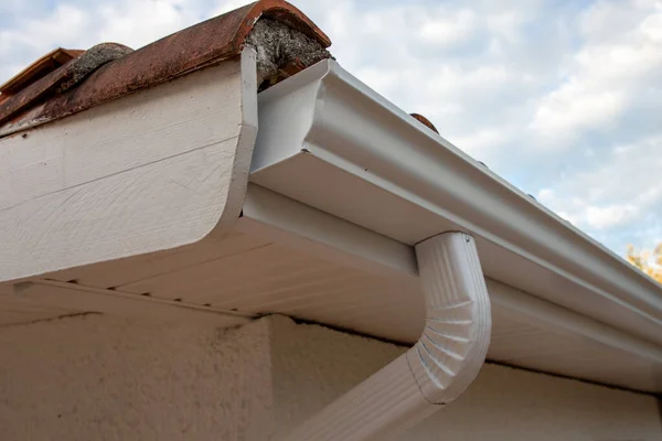 Cleaned white new aluminum gutter rain systems and drain pipes on restoration house