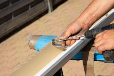 manufacturing, assembly of aluminum gutters by the artisanal hands of men