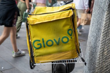 Milan, İtalya - 01 08 2024: Glovo logosu ve yazı dağıtım sırt çantası Milano sokaklarında bisiklet üzerinde