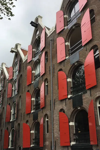 Converted warehouse with painted window red shutters in Amsterdam Holland