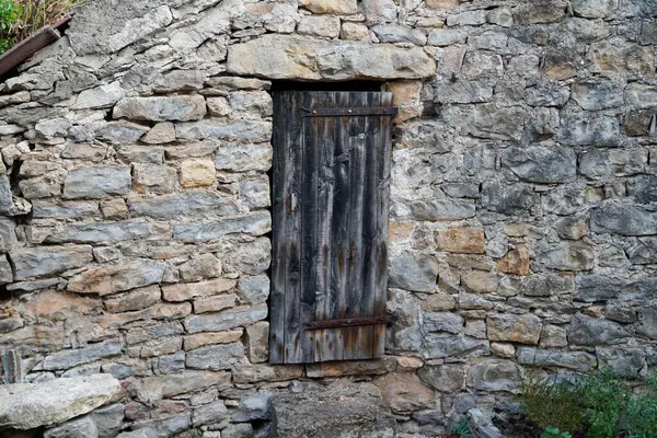 old farmhouse facade with typical stone wall and classic wooden shutter window closed from central France caussenarde in Lozere Hures la Parade village