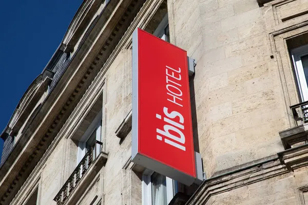 stock image Bordeaux , France -  03 21 2024 : Ibis hotel brand text and sign red logo on facade hostel wall building entrance