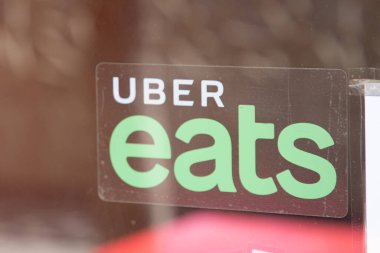 Bordeaux, Fransa - 03 12 2024: Uber işaret logosu yiyor ve markalı bir restoran restoranı insan bisikleti ile yiyecek dağıtıyor