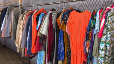 shop specializing in second hand clothing store sale of women clothing with a carrier full of trendy girls clothes clipart