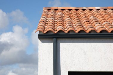 aluminum grey gutter on modern roof of the building and gray downpipe on facade wall home
