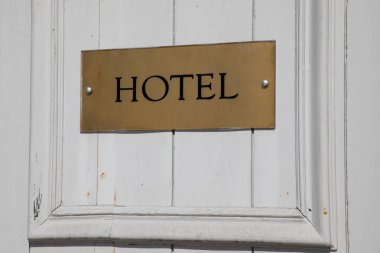 Turizm şehrinde kapı girişinde duvar binası cephesi tabelasında otel tabelası.