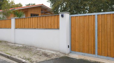 Duvardaki tahta çitle çelik sütun yapısı sokak ahşap bariyer evi manzarayı koruyor.
