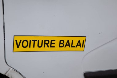 Voiture Balai Fransızca yazı tabelası, süpürge vagonu sarkık erzak ve korunmak için arkada konumlanmış teçhizat anlamına geliyor.