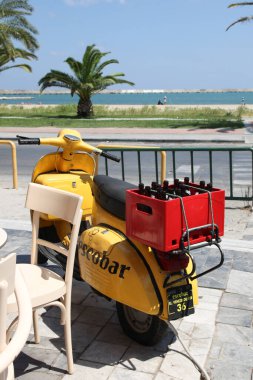 Rethimno , Greece - 12 30 2024 : vespa scooter vintage with yellow paint for brand sign and text brand beer bar escobar in Crete island city street parked clipart